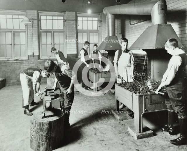 Boys using forges in a blacksmith's shop, Beaufoy Institute, London, 1911. Artist: Unknown.