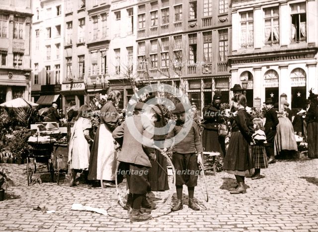 Boys with hoops at a market, Rotterdam, 1898.Artist: James Batkin