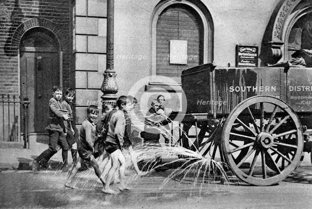 Boys following the Poplar Borough Council water cart, London, 1926-1927. Artist: Unknown