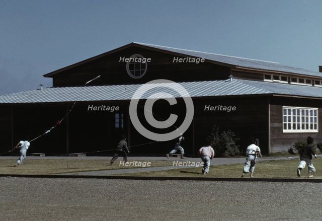 Boys flying a kite in front of community center, FSA ... camp, Robstown, Tex., 1942. Creator: Arthur Rothstein.