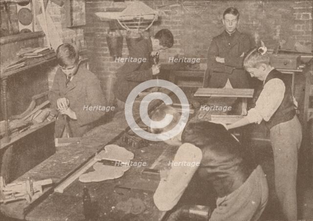 Boys of Harrow School making splints, crutches and other articles for the wounded, c1916 (1928). Artist: Unknown.