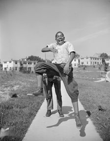 Boys playing leap frog near the project, Frederick Douglass housing project, Anacostia, D.C., 1942. Creator: Gordon Parks