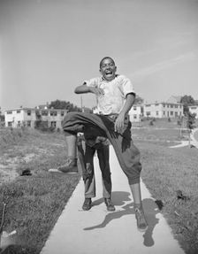 Boys playing leap frog near the project, Frederick Douglass housing project, Anacostia, D.C., 1942. Creator: Gordon Parks