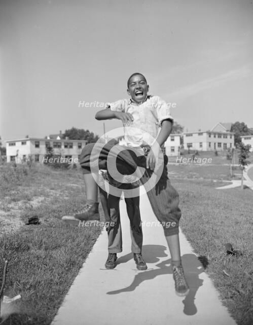 Boys playing leap frog near the project, Frederick Douglass housing project, Anacostia, D.C., 1942. Creator: Gordon Parks.
