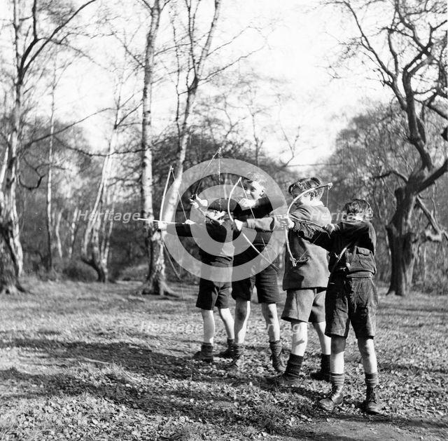 Boys shooting with bows and arrows in Hampstead, London, c1950s. Creator: Henry Grant.