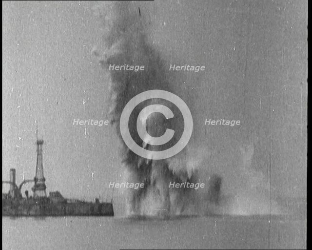 Bombs Dropped from Planes Exploding near a Warship, 1922. Creator: British Pathe Ltd.