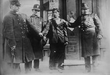Battered striker with policemen, Philadelphia, 1910. Creator: Bain News Service