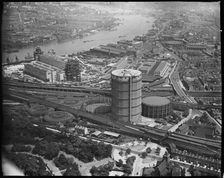 Battersea Power Station under construction and the Gas Holder Station, Nine Elms, London, c1930s. Creator: Arthur William Hobart