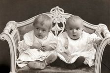 Baby twins on a small sofa. Creator: Unknown