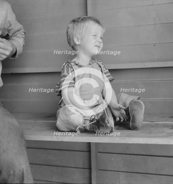Baby with club feet wearing homemade splints, FSA camp, Tulare County, California, 1939. Creator: Dorothea Lange.
