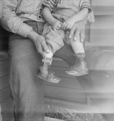 Baby with club feet wearing homemade splints, FSA camp, Tulare County, California, 1939. Creator: Dorothea Lange