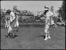 Bampton Morris troupe performing in a Pipe Dance with a fiddle player, Oxfordshire, 1920-30. Creator: George R Long