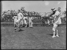 Bampton Morris troupe performing with a fiddler and someone holding a broom aloft, Oxon, 1920-30. Creator: George R Long