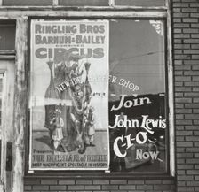 Barber shop window [with circus poster] in Birmingham, Alabama, 1937-01 - 1937-02. Creator: Arthur Rothstein