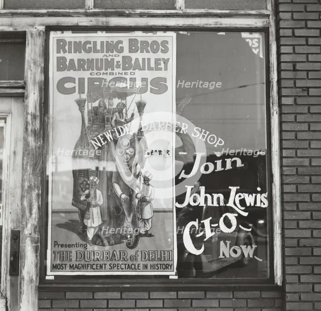 Barber shop window [with circus poster] in Birmingham, Alabama,  1937-01 - 1937-02. Creator: Arthur Rothstein.