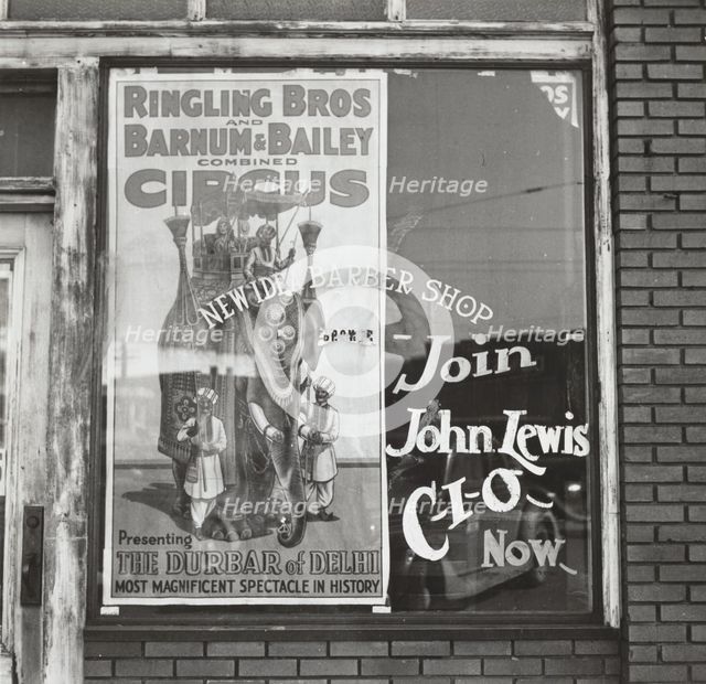 Barber shop window [with circus poster] in Birmingham, Alabama,  1937-01 - 1937-02. Creator: Arthur Rothstein.