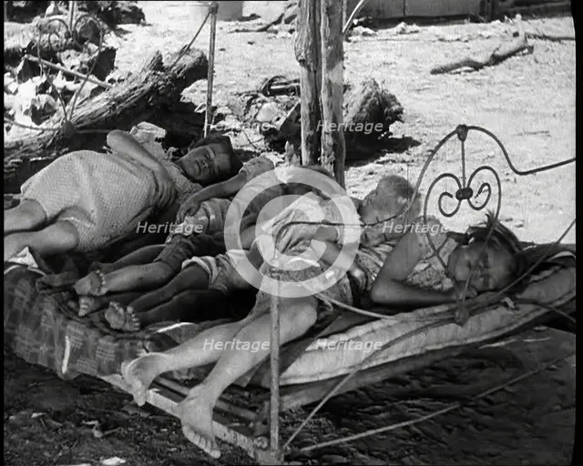 Barefoot Female Children Sleeping On a Bedframe Outside, 1932. Creator: British Pathe Ltd.