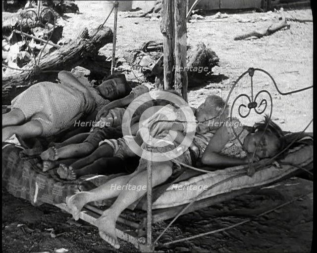 Barefoot Female Children Sleeping On a Bedframe Outside, 1932. Creator: British Pathe Ltd.
