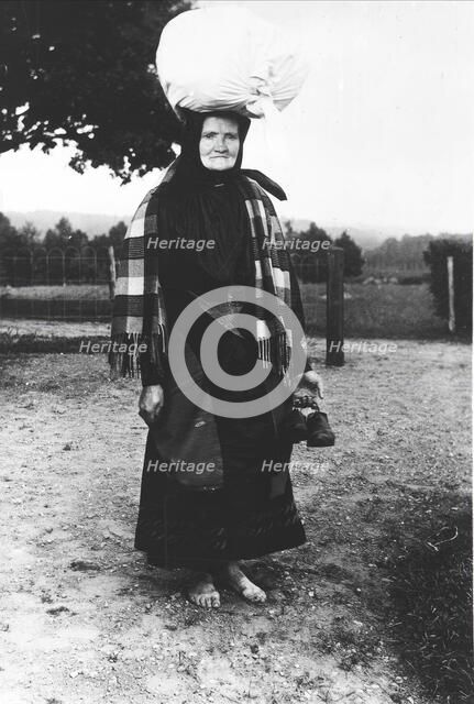 Barefoot woman carrying a sack on her head, walking to sell tissues, Mark's district,..., 1900-1910. Creator: Unknown.
