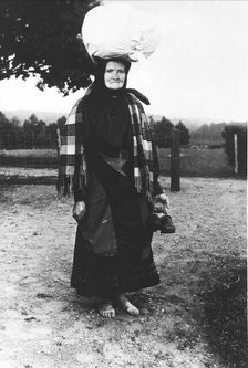 Barefoot woman carrying a sack on her head, walking to sell tissues, Mark's district,..., 1900-1910. Creator: Unknown