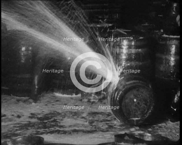 Barrels of Alcohol in a Cellar Being Destroyed During Prohibition, 1930. Creator: British Pathe Ltd.