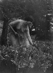 Beyer, Hilda, Miss, picking flowers in a garden, 1915 Apr. 26. Creator: Arnold Genthe