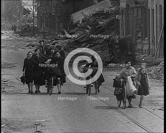 Belgian Refugees Fleeing Their Town Along Bomb Damaged Road, 1940. Creator: British Pathe Ltd.
