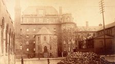 Bellevue Hospital, New York City: hospital buildings with a tower; a pile of bricks in the fore... Creator: Unknown