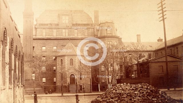 Bellevue Hospital, New York City: hospital buildings with a tower; a pile of bricks in the fore... Creator: Unknown.