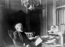 Benjamin Franklin Tracy, Secretary of the Navy, half-length portrait..., looking at paper, c1890. Creator: Frances Benjamin Johnston