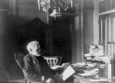 Benjamin Franklin Tracy, Secretary of the Navy, half-length portrait..., looking at paper, c1890. Creator: Frances Benjamin Johnston