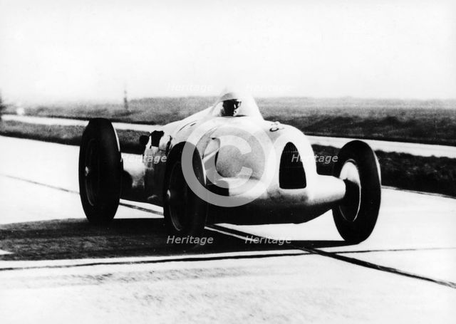 Bernd Rosemeyer in Auto Union record-breaking car, 1937. Artist: Unknown