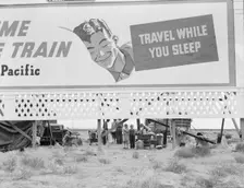 Billboard along U.S. 99 behind which three destitute families..., Kern County, California, 1938. Creator: Dorothea Lange