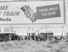Billboard along U.S. 99 behind which three destitute families..., Kern County, California, 1938. Creator: Dorothea Lange
