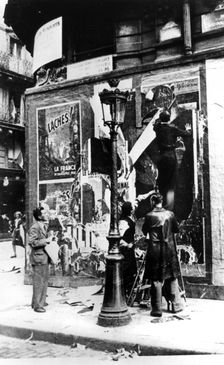 Billboard with men putting up propaganda posters, Paris, World War II, 1939-1945