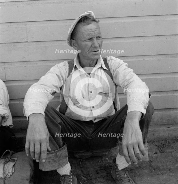 Bindle stiff, used to be logger, Side of Pastime Café, Tulelake, Siskiyou County, California, 1939. Creator: Dorothea Lange.
