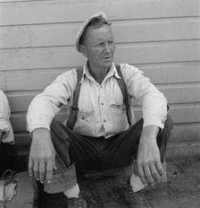 Bindle stiff, used to be logger, Side of Pastime Café, Tulelake, Siskiyou County, California, 1939. Creator: Dorothea Lange