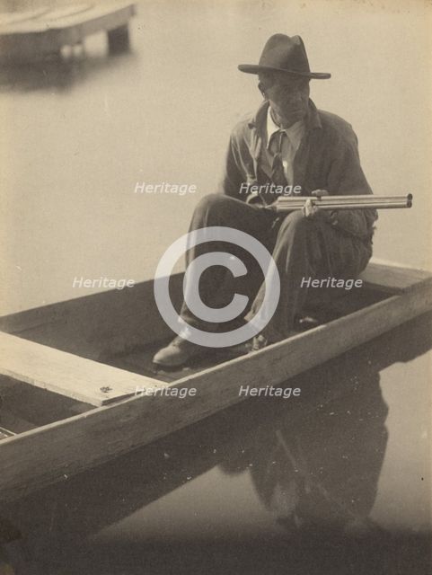 Black Man in Flat Boat, Holding Shotgun, 1929-1930. Creator: Doris Ulmann.