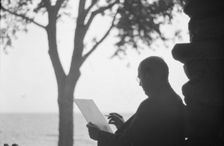 Bruce, Ned, Mr., reading and writing outdoors, 1915? Creator: Arnold Genthe