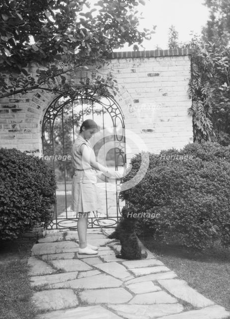 Brady, Genevieve, Miss, with dog, standing outdoors, between 1928 and 1931. Creator: Arnold Genthe.