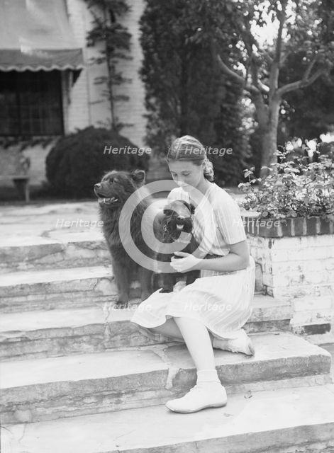 Brady, Genevieve, Miss, with dogs, seated outdoors, between 1931 and 1934. Creator: Arnold Genthe.
