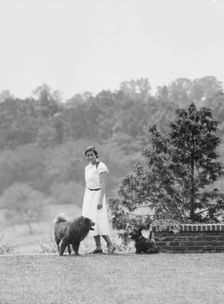 Brady, Victoria, Miss, with dogs, standing outdoors, 1931 July 14. Creator: Arnold Genthe
