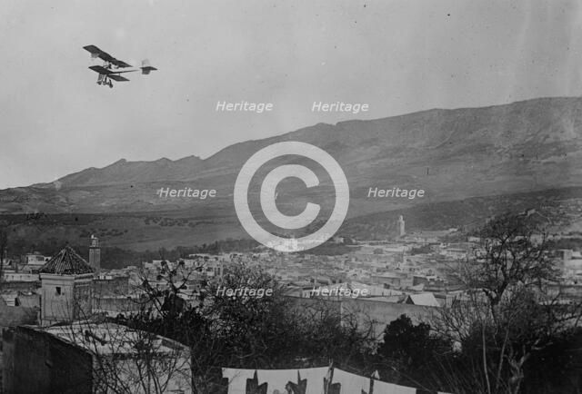 Breguet biplane, type 1910, flying over a town, possibly in Morocco, between c1910 and c1915. Creator: Bain News Service.