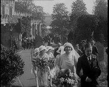 Bride and Groom Walking Through Gardens of Wedding Venue, Followed by Bridesmaids, as Their..., 1921 Creator: British Pathe Ltd