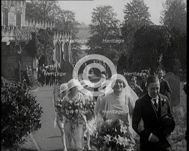 Bride and Groom Walking Through Gardens of Wedding Venue, Followed by Bridesmaids, as Their..., 1921 Creator: British Pathe Ltd.