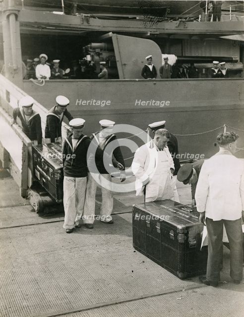 Bringing ashore the steel lined cases from the decks of H.M.S. Hood, July 1935. Creator: Topical Press Agency.