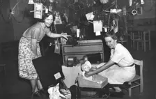 Brisbane Kindergarten Teachers College students/staff with presents and the Christmas tree, 1955. Creator: Unknown