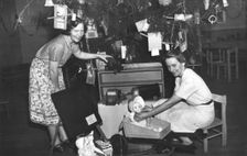 Brisbane Kindergarten Teachers College students/staff with presents and the Christmas tree, 1955. Creator: Unknown