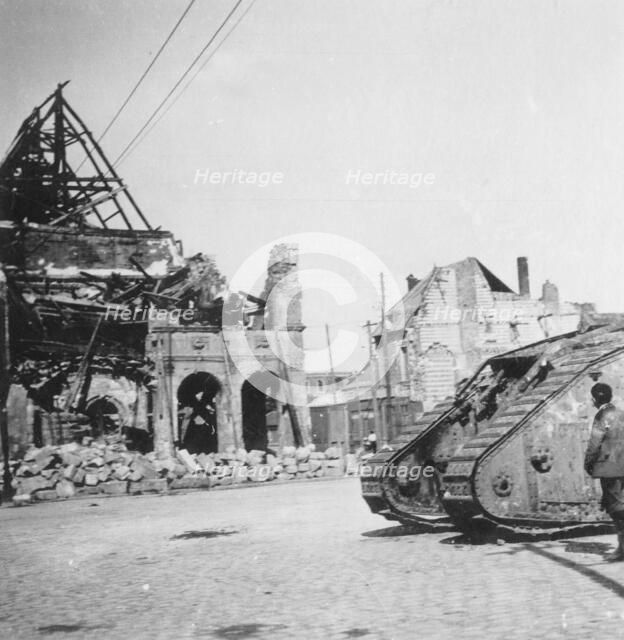 British tank in front of ruined buildings, Peronne, France, World War I, c1916-c1918. Artist: Nightingale & Co