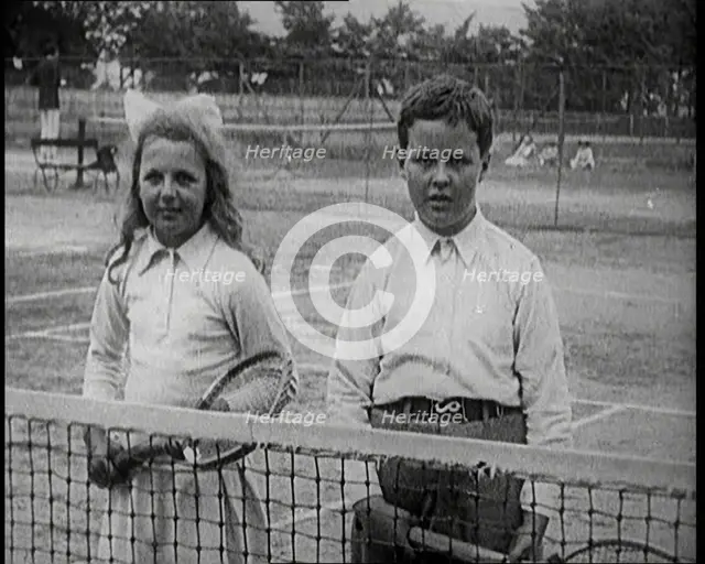 British Tennis Player Betty Nuttall as a Child, Standing on a Tennis Court With a Young Boy, 1921. Creator: British Pathe Ltd.